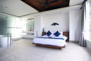 Ein modernes Schlafzimmer mit einem großen Bett, einer integrierten Dusche und einem Deckenventilator.