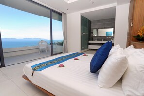 Ein Schlafzimmer mit Bett, Meerblick, Bad und Balkon.
