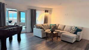 Ein Wohnzimmer mit einer Couch, einem Couchtisch und einem Kicker.