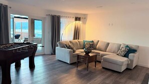 Ein Wohnzimmer mit einer Couch, einem Couchtisch und einem Kicker.