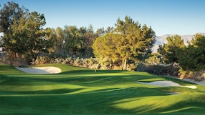 A golf course with sand bunkers, trees, and a clear sky. - Prime location for festivals, golf, and restaurants w/2 full bedrooms & baths (Palm Desert)