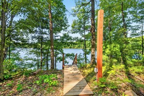 A wooden dock leading to a small cabin by a lake surrounded by trees. - Hummingbird Grove - A Private Escape (Birchwood)