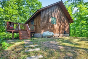Eine Holzhütte mit Veranda und Treppe zu einer Terrasse.