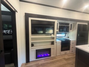 Een moderne keuken met inbouwapparatuur, een open haard en een raam.