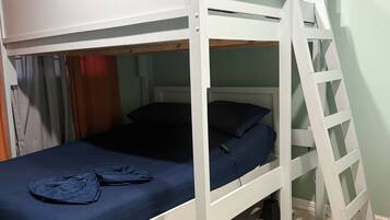 A bunk bed with a ladder, a desk, and a chair.