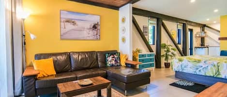 A living room with a sofa, coffee table, and a painting on the wall.