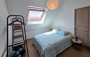 A bedroom with a bed, a window, a hanging chair, and a door. - Villa avec piscine privée (CharonVille)