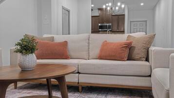 A modern living room with a sofa, a coffee table, and a potted plant.