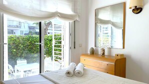 Ein Hotelzimmer mit einem Bett, einem Schminktisch, einem Spiegel und Blick auf Grünfläche.