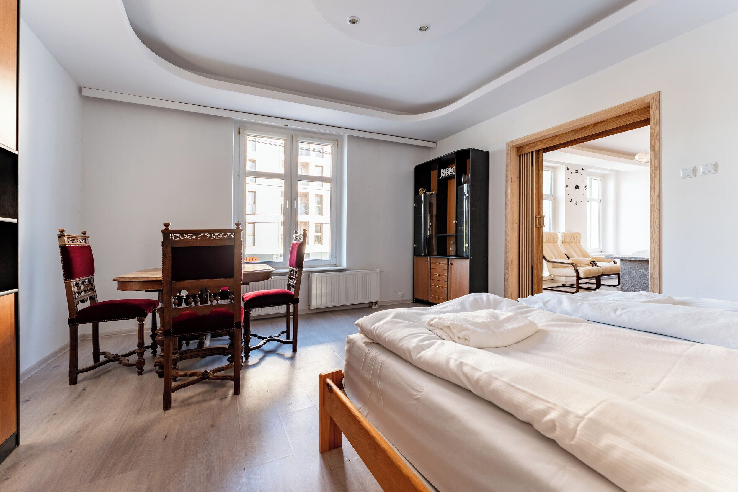 Une chambre à coucher avec un lit, un bureau, une chaise et une armoire.