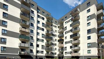 Un edificio residencial de varios pisos con balcones, techo plano y cielo despejado.