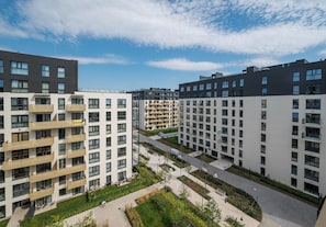 A modern apartment complex with multiple balconies, a central courtyard, and a clear sky. - Wola Redutowa Superior Apartment (Warszawa)
