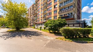 Ein mehrstöckiges Wohngebäude mit Balkonen, einem Parkplatz und Grünflächen.