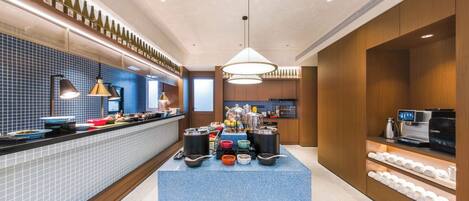 Una cocina moderna con una isla central, una alacena para vinos y una zona de café.