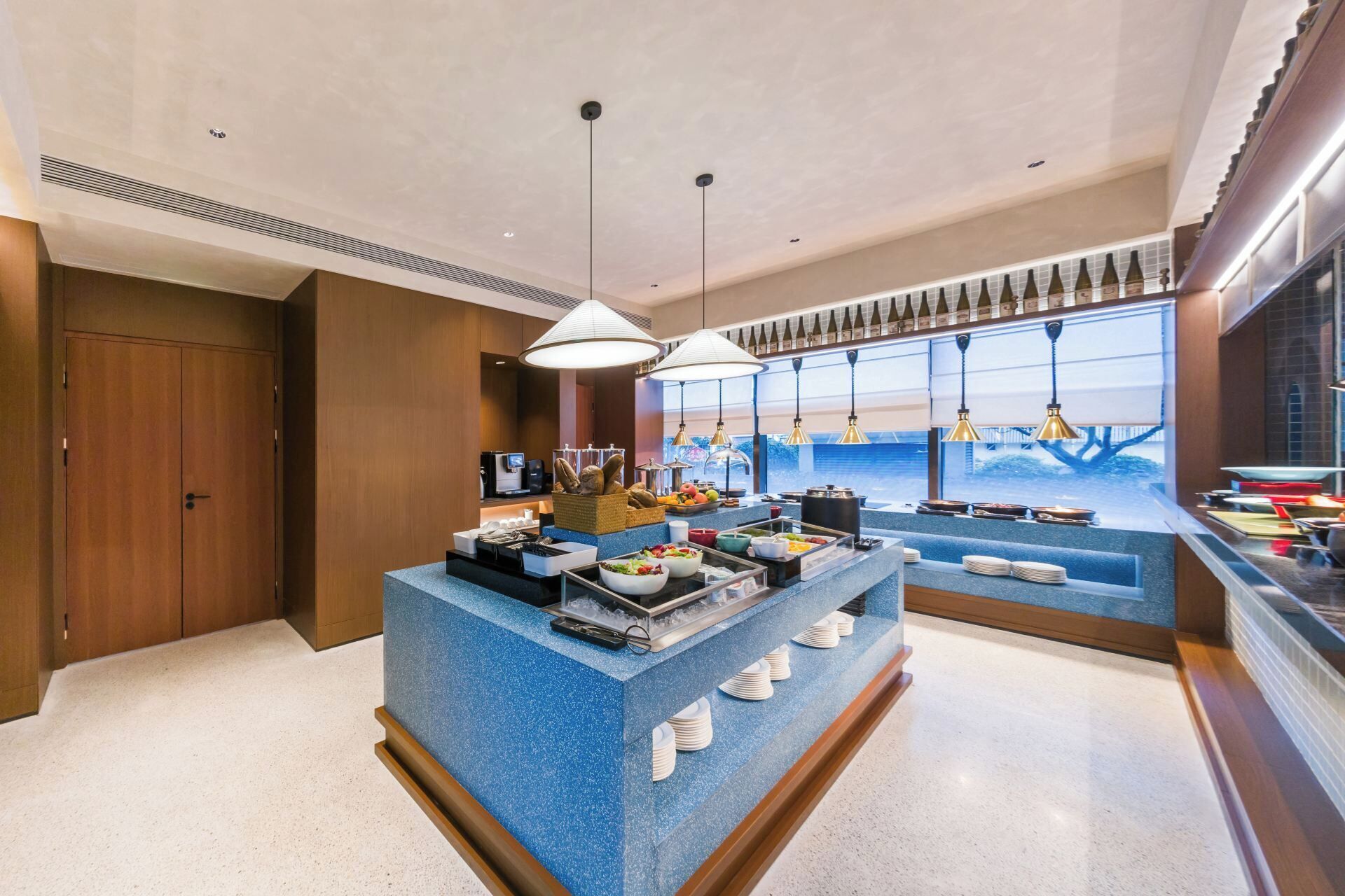 A hotel breakfast area with a buffet setup, including various food items and condiments.