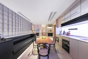 A modern kitchen with a central island, built-in appliances, and a large window. - Shanghai Xujiahui Grow Suisse Place Apartment Hotel (Shanghai)