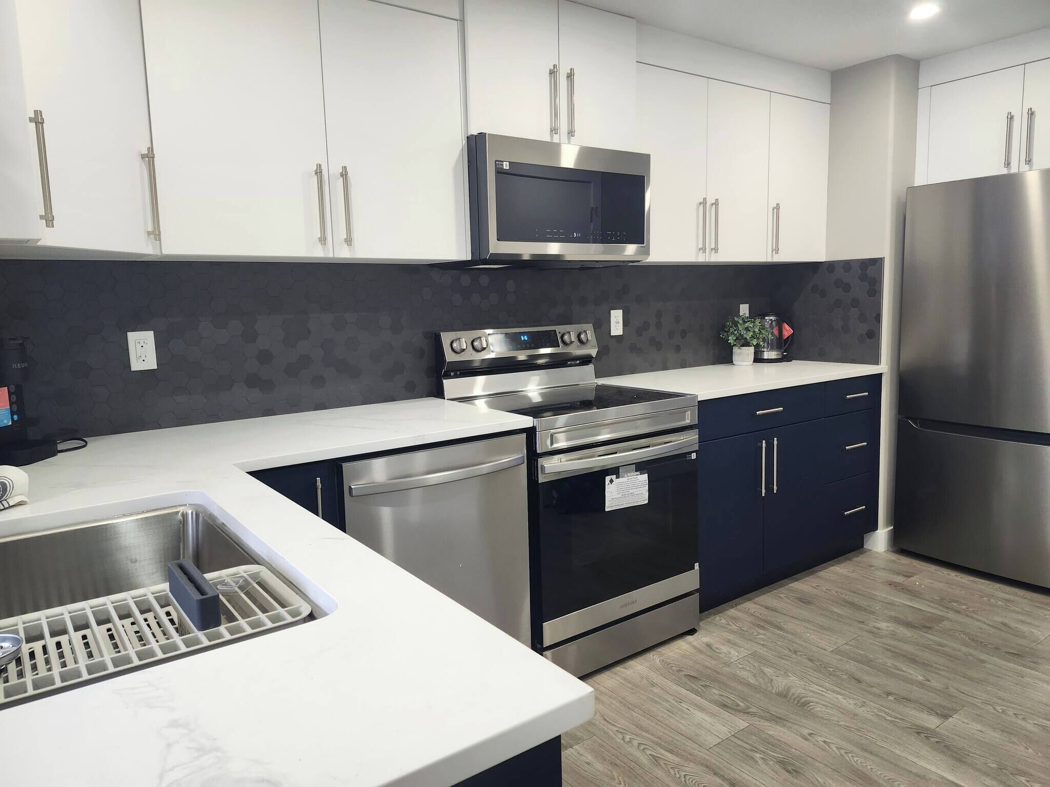 A modern kitchen with stainless steel appliances, a microwave, oven, and dishwasher.