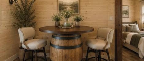 Ein Holzinterieur mit einem runden Holztisch, zwei Stühlen und einem Blumentopf.