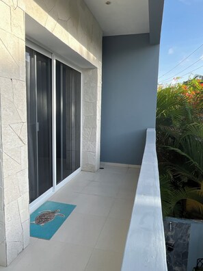 A balcony with a tiled floor, a blue mat, and a stone wall. - OTOMI HOUSE, PUERTO MORELOS (Puerto Morelos)
