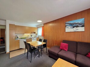 A compact living space with a kitchenette, a dining area, and a sofa. - Am Biel 3 by Interhome (Saas-Fee)