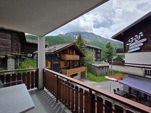 A balcony with a view of traditional wooden buildings and a mountain in the background. - Am Biel 3 by Interhome (Saas-Fee)