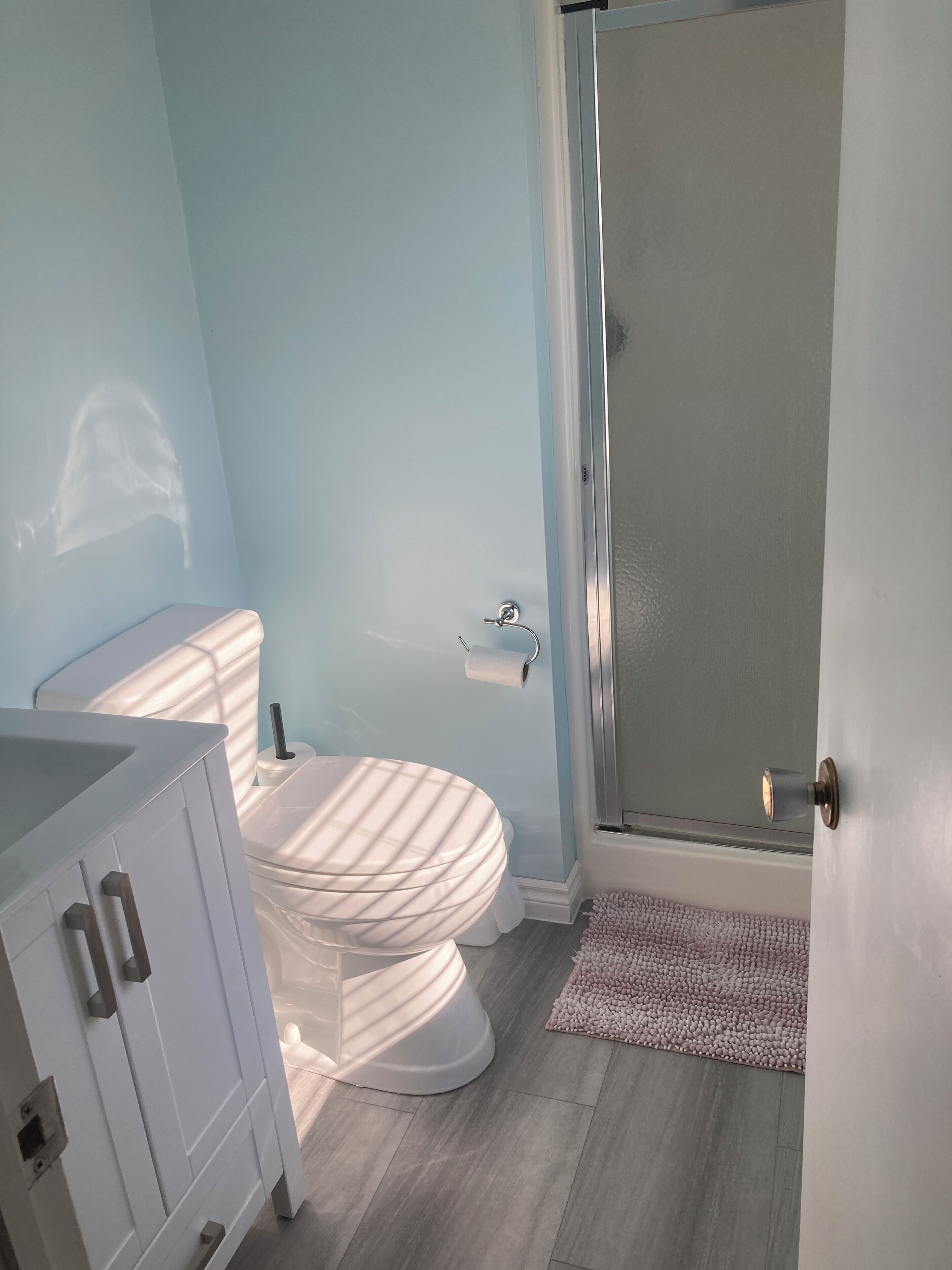 Une salle de bain comprenant des toilettes, un espace douche et un lavabo.