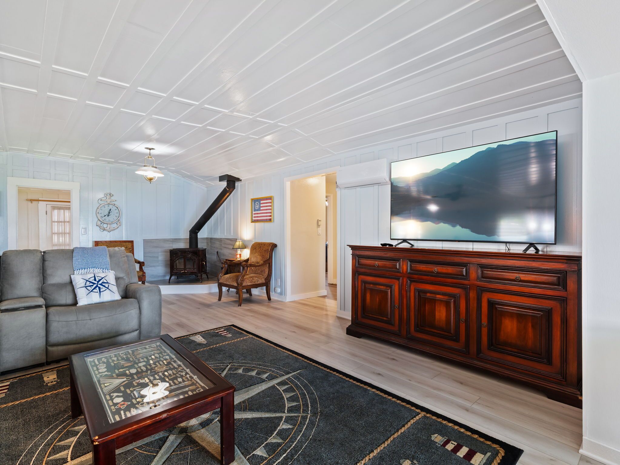 Un salon spacieux doté d’une cheminée, d’un grand téléviseur à écran plat et d’un coin salon confortable.