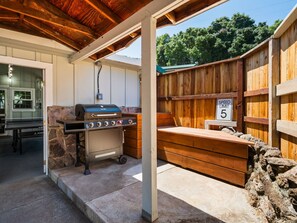 Eine Terrasse im Freien mit Grill, Geschwindigkeitsbegrenzungsschild und einer Steinmauer.
