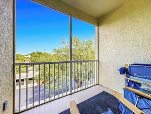 Ein Balkon mit Blick auf Bäume und ein Gebäude.