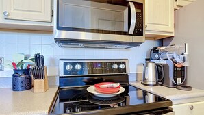 Une cuisine équipée d’un four à micro-ondes, d’une cuisinière et d’une machine à café.