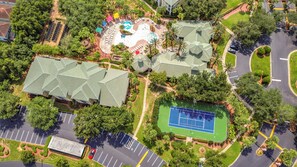 Ein Luftbild eines Resorts mit mehreren Gebäuden, einem Schwimmbad, Tennisplätzen und Parkbereichen.