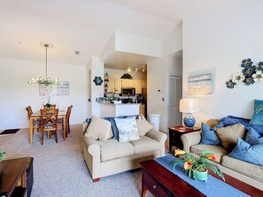 Ein Wohnzimmer mit einer Couch, einem Couchtisch und einem Essbereich mit Stühlen und Tisch.