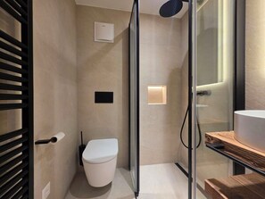 A modern bathroom with a glass shower enclosure, a toilet, and a sink with a wooden countertop. - Alphubel Unlimited 23 by Interhome (Saas-Fee)