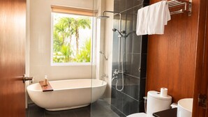 Ein Badezimmer mit einer freistehenden Badewanne, einer Dusche und einem WC.