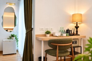 A modern room with a desk, chair, lamp, and a refrigerator. - LUMA Phrom Phong (Bangkok)