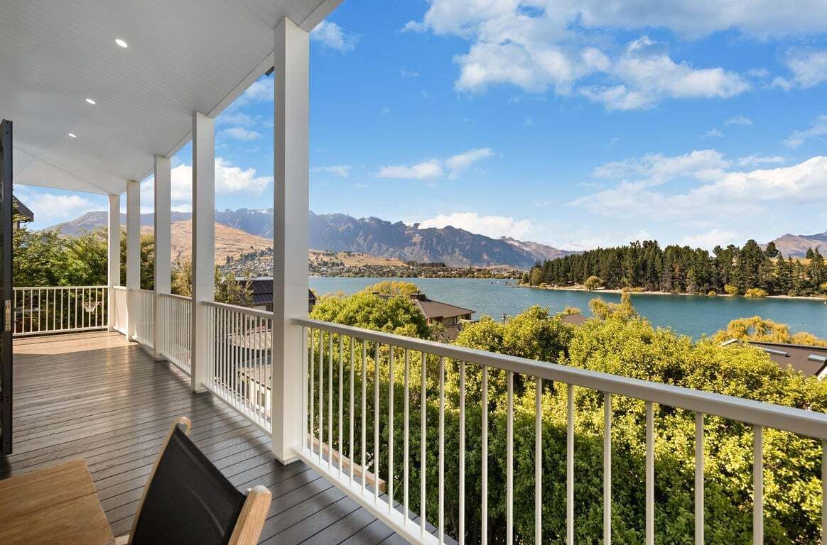 A covered outdoor area with a view of a lake and mountains.