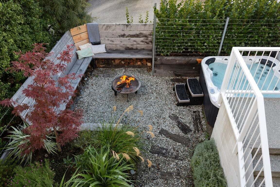 A rooftop patio with a fire pit, seating area, and a hot tub.