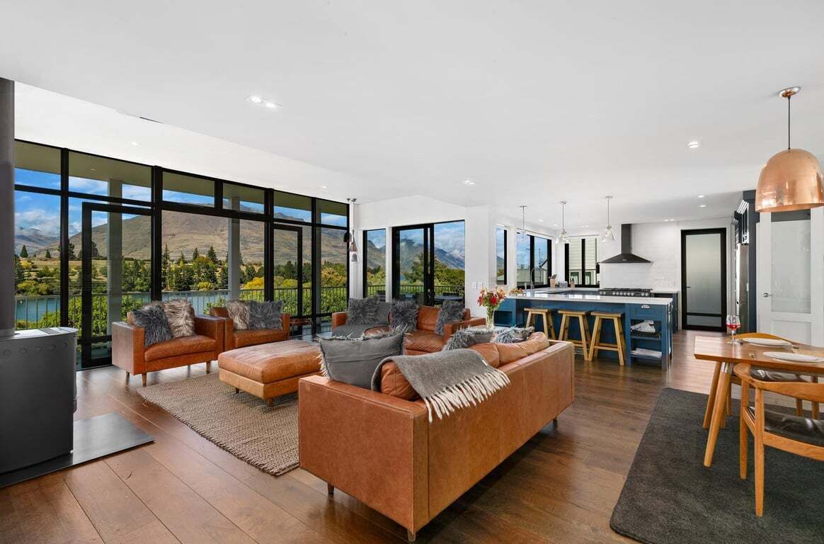 A spacious living area with a large sofa, a dining table, and a kitchen in the background.