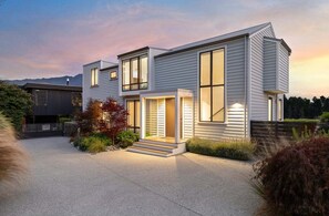A modern two-story house with a large front porch and a driveway. - 10 The Terrace (Queenstown)