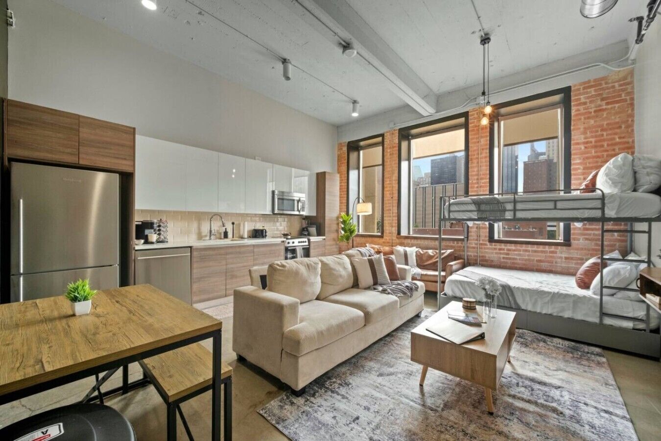 A modern apartment with a kitchen, living area, and a bunk bed.