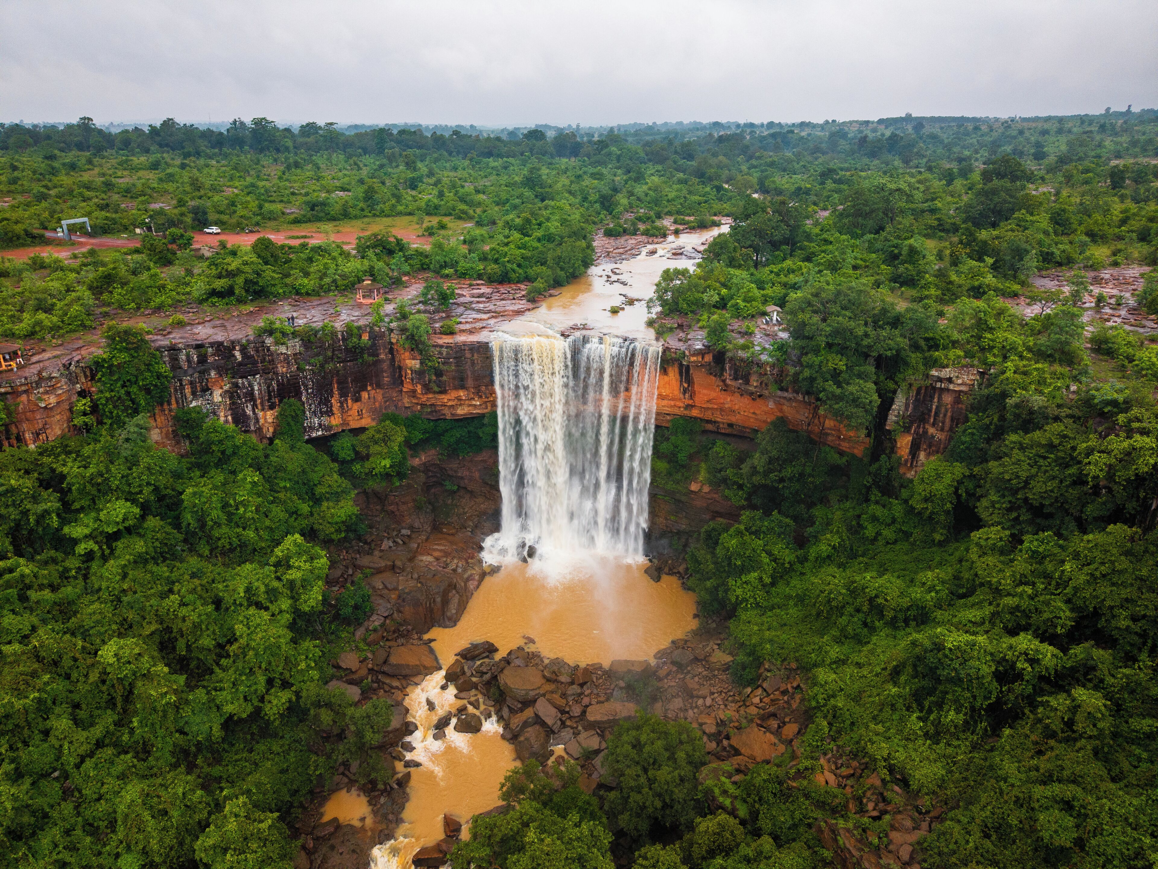 Ein Wasserfall, umgeben von dichtem, grünen Wald.