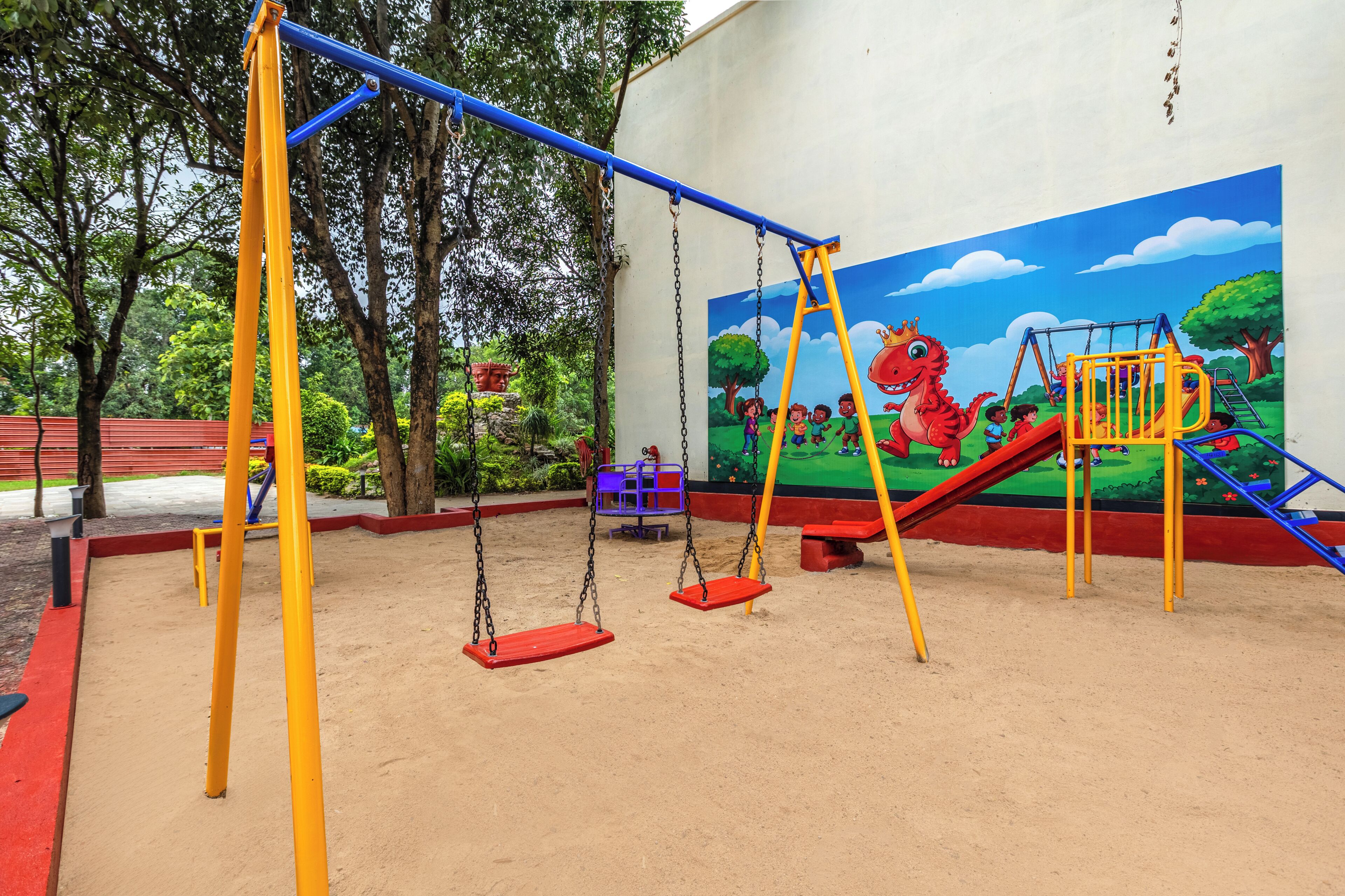A playground with swings, a slide, and a mural of children playing.