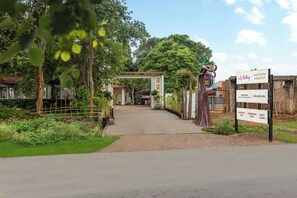 A pathway leading to a building with a sign indicating amenities such as a banquet hall, swimming pool, and party lawn. - Sterling Naman Bastar Jagdalpur (Jagdalpur)