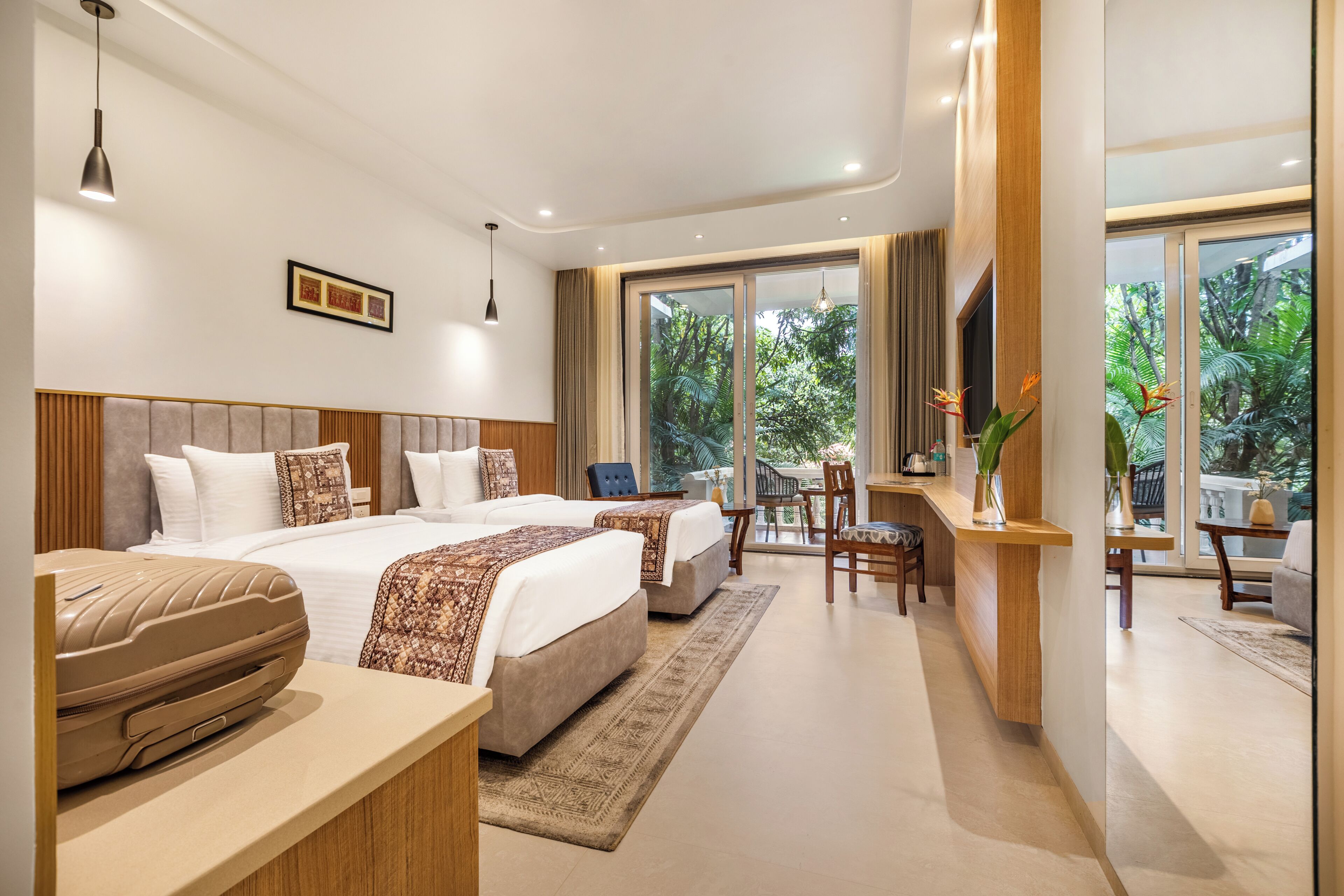 A modern hotel room with a large bed, a desk, and a view of the outdoors.