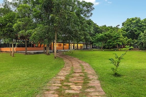 Un sendero conduce a un edificio de fachada de ladrillo y césped verde.