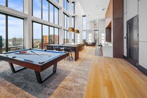 Una habitación de hotel moderna con mesa de billar, zona de comedor y cocina.