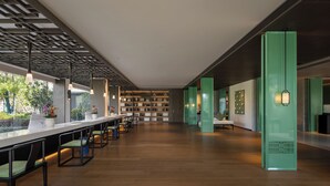 Un intérieur moderne avec un long comptoir, des chaises et une bibliothèque.