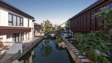 A narrow waterway flanked by modern buildings with a traditional bridge.