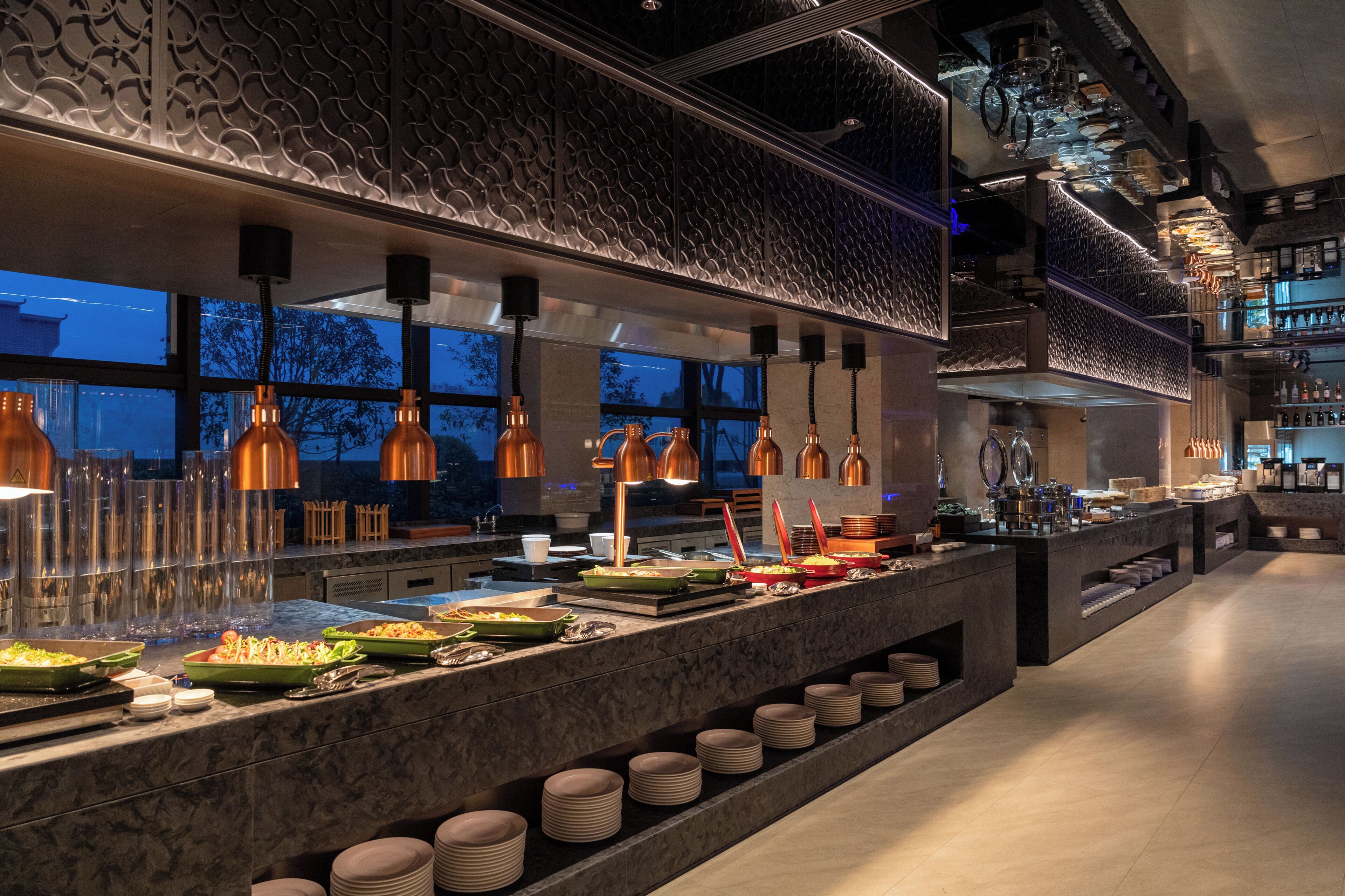 A buffet setup with multiple food stations, a variety of dishes, and a modern interior design.