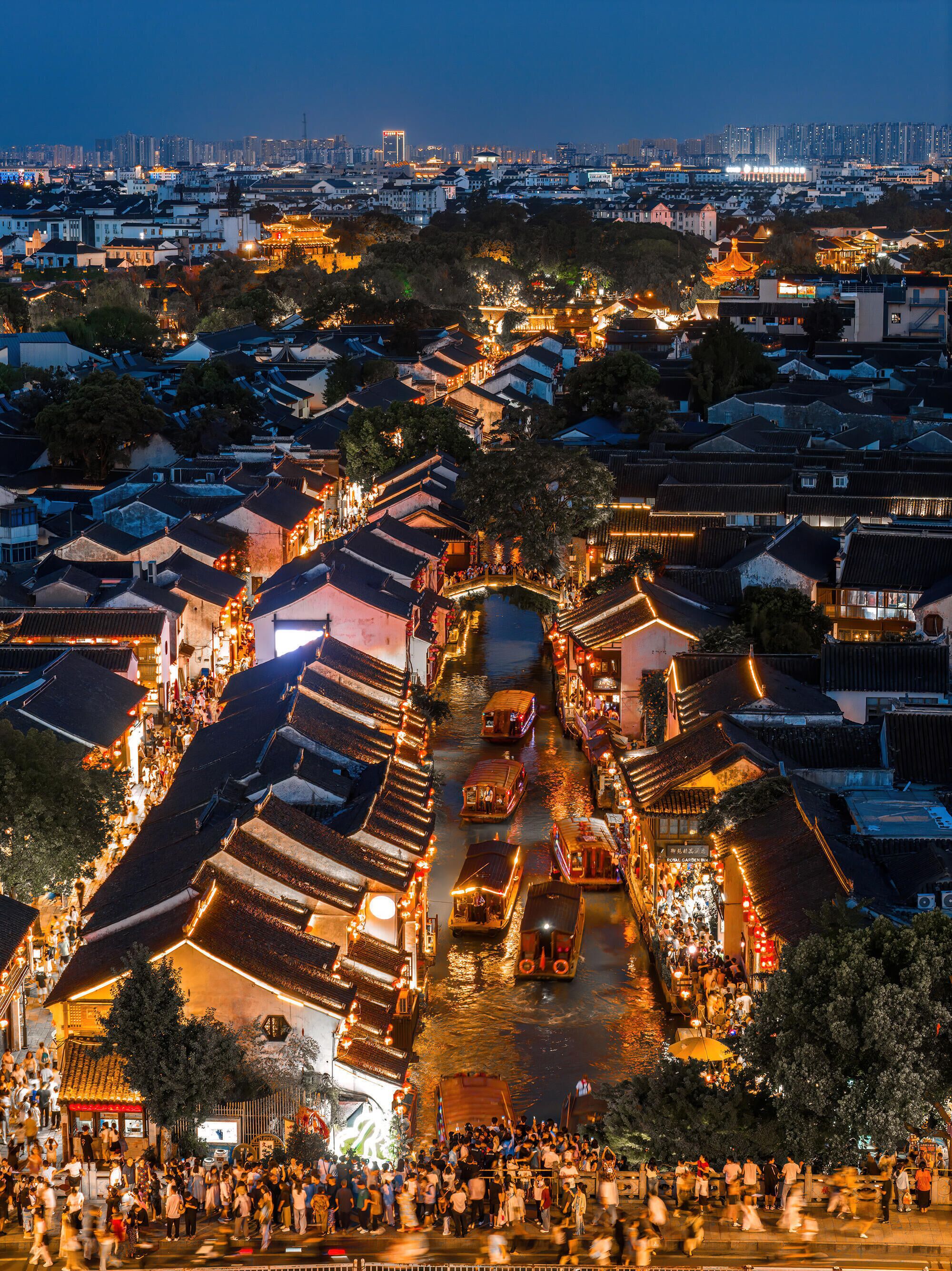 A traditional town with narrow streets and waterway, featuring historic buildings and a crowd of people.